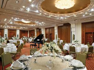 a grand room with tables and a grand piano at Mövenpick Hotel Bahrain in Manama +197 photos