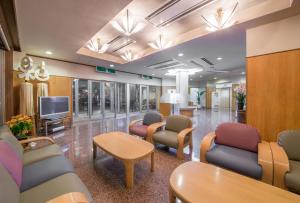 a hospital waiting room with chairs and a tv at Takayama City Hotel Four Seasons in Takayama