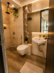 a bathroom with a toilet and a sink at LuxeBnb - The Olive Maple Room in Pune