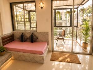 a living room with a bench and a window at LuxeBnb - The Olive Maple Room in Pune