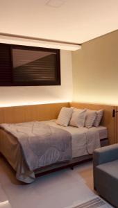 a bedroom with a bed with a window on the wall at Studio Chico 02 in Espirito Santo Do Pinhal