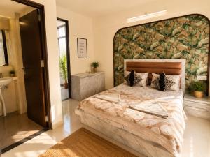 a bedroom with a large bed with a large wall at LuxeBnb - The Olive Maple Room in Pune +2 photos