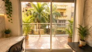 a large window with a view of a courtyard at LuxeBnb - The Olive Maple Room in Pune