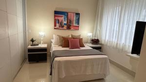 a bedroom with a large bed with pillows at VR requinte total ar e garagem in Guarapari