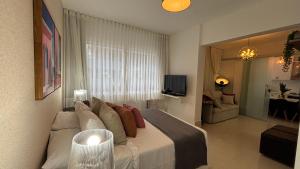 a bedroom with a large bed and a living room at VR requinte total ar e garagem in Guarapari