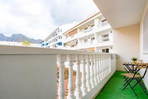 a balcony with green flooring and white buildings at La Posadilla in Adeje