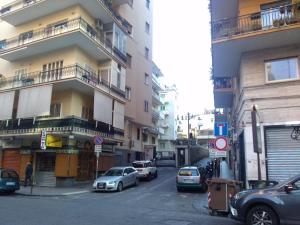 ナポリにあるDomus Aureaの高層ビルの横に車を停めた街道