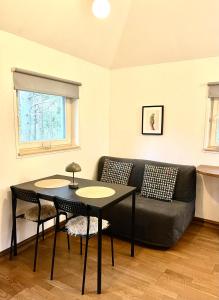 a living room with a black couch and a table at Heiniku Home in Elbiku +26 photos