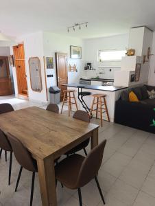 a living room and kitchen with a wooden table and chairs at Júlia Vendégház in Sárospatak
