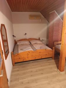a bedroom with a wooden bed in a room at Júlia Vendégház in Sárospatak