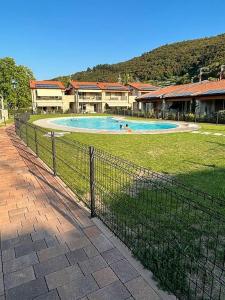 a fence around a swimming pool with people in it at Villetta Pima in Garda