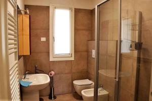 a bathroom with a toilet and a sink and a shower at Villetta Pima in Garda +10 photos