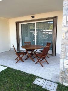 a wooden table and chairs on a patio at Villetta Pima in Garda
