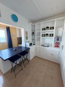 a kitchen with white cabinets and a blue table at apartamento el camarote in Fasnia +4 photos
