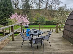 a table and chairs on a wooden deck at Mountain Edge Resort Mega pod 4 with Hot Tub in Church Stretton