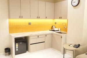 a kitchen with a counter with a sink and a clock at Vatsalya by Vrinda in Nāthdwāra