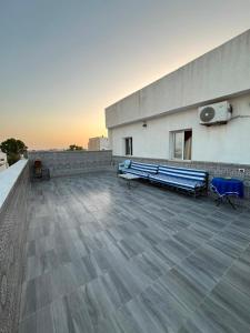 a rooftop with two blue benches on a building at Dar zgolli in Kelibia