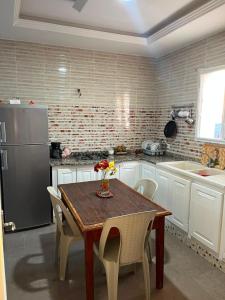 a kitchen with a wooden table and a refrigerator at Dar zgolli in Kelibia +8 photos