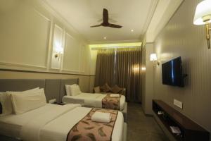 a hotel room with two beds and a ceiling fan at Centre Point Amravati in Amrāvati