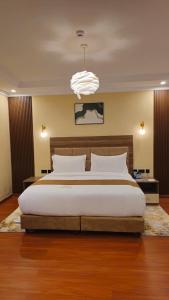 a bedroom with a large bed and a chandelier at Sebai Laxury Suit in Nairobi