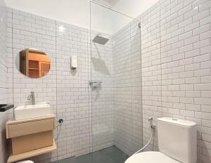 a white bathroom with a toilet and a sink at Tamashii Boutique Hotel in Bandung +33 photos