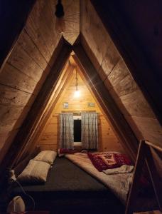 a small bed in the middle of a attic at Cottage Uskoci in Žabljak