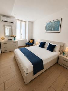 a bedroom with a large white bed with blue pillows at Luna Luxury Suite in Bergamo