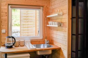 a kitchen with a sink and a window at Mama Chata a Mama Spa Beskydy in Bílá