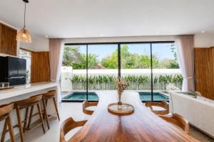 a kitchen and living room with a wooden table at Santo Villa Uluwatu in Bingin Beach