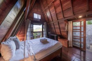 a bedroom with a bed in a room with wooden walls at Medukuh Point Hill in Karangasem +7 photos