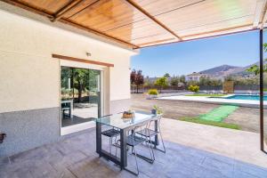 a patio with a table and a view of a pool at Cubo's Maipa Rural House in Loja