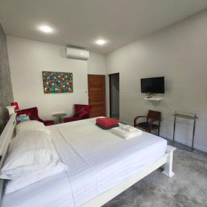 a bedroom with a white bed and a tv at Krabi Home and Beyond-Ao Nang in Ao Nang Beach