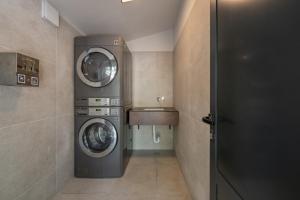 a laundry room with two washing machines and a sink at Porton Nature Hideouts Pitches in Rovinj