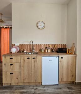a kitchen with a white refrigerator and a clock on the wall at Marivar living in Nea Fokea