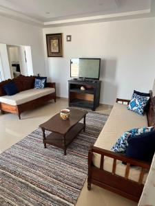 a living room with two couches and a flat screen tv at Dar zgolli in Kelibia