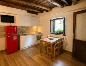 a kitchen with a red refrigerator and a table at Casa Runcis in Cavasso Nuovo