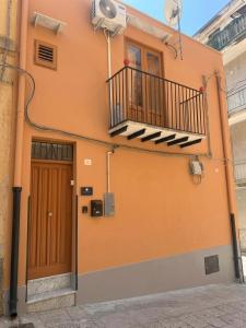 ein Gebäude mit Balkon und Tür in der Unterkunft Moonlight Rooms in Termini Imerese