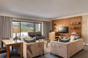 a living room with two couches and a tv at Drakensberg Sun Resort in Winterton