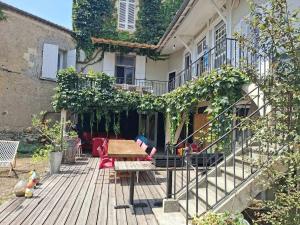 a wooden deck with a table and chairs in front of a building at Pause ton sac in Condom