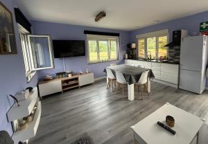 a kitchen and living room with a table and a refrigerator at La Caleya de Ozanes in Ozanes
