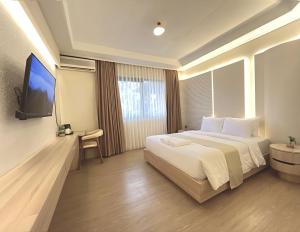 a hotel room with a bed and a flat screen tv at Tamashii Boutique Hotel in Bandung