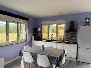 a kitchen with a table with chairs and a refrigerator at La Caleya de Ozanes in Ozanes