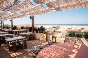a patio with tables and chairs and the beach at Adalya Art Side - Ultra All Inclusive in Side