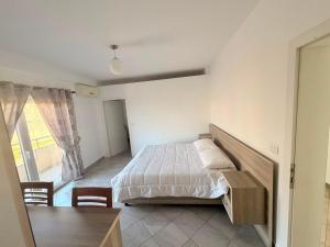 a bedroom with a bed and a table and a window at Hotel Klaivi in Lezhë