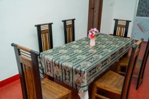 a table with a vase of flowers on top of it at Nilaveli Beach Bungalow in Trincomalee