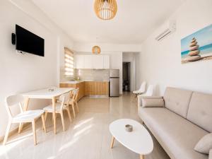 a living room with a couch and a table and a kitchen at Eleftheria Hotel & Apartments in Ornos