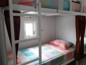 a bedroom with a bunk bed with a window at Huize Jon Hostel in Malang