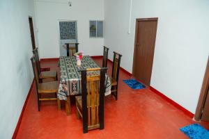 a dining room with a table and chairs and a door at Nilaveli Beach Bungalow in Trincomalee +36 photos