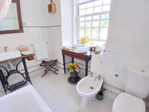a bathroom with a sink and a toilet and a desk at Esposende Garden in Esposende +23 photos