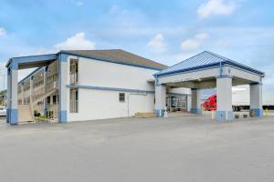 a large white building with a garage with a red truck at Ole South Inn Jackson I 40 TN in Denmark